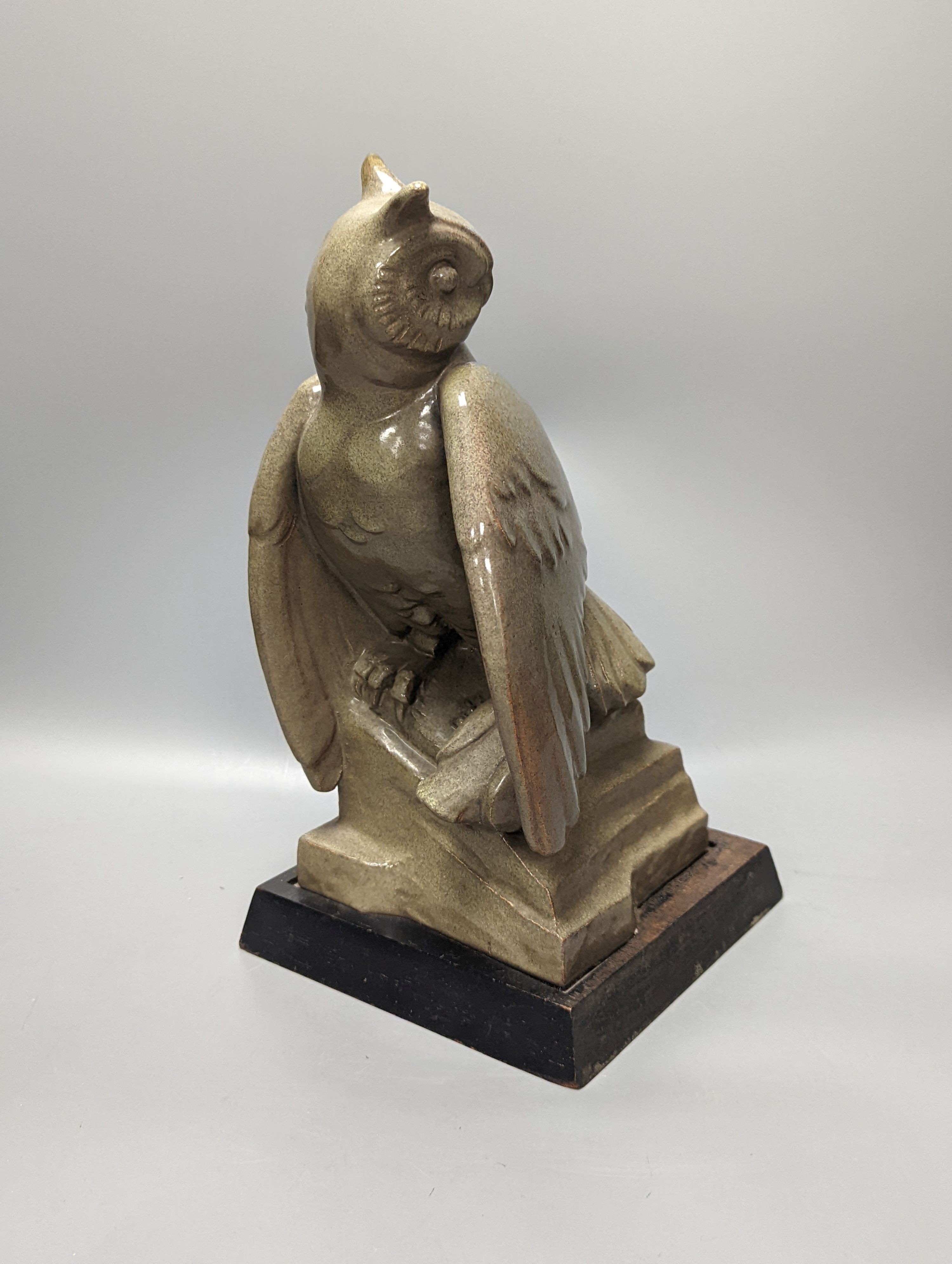 A glazed pottery owl model, 30cm, on wood plinth